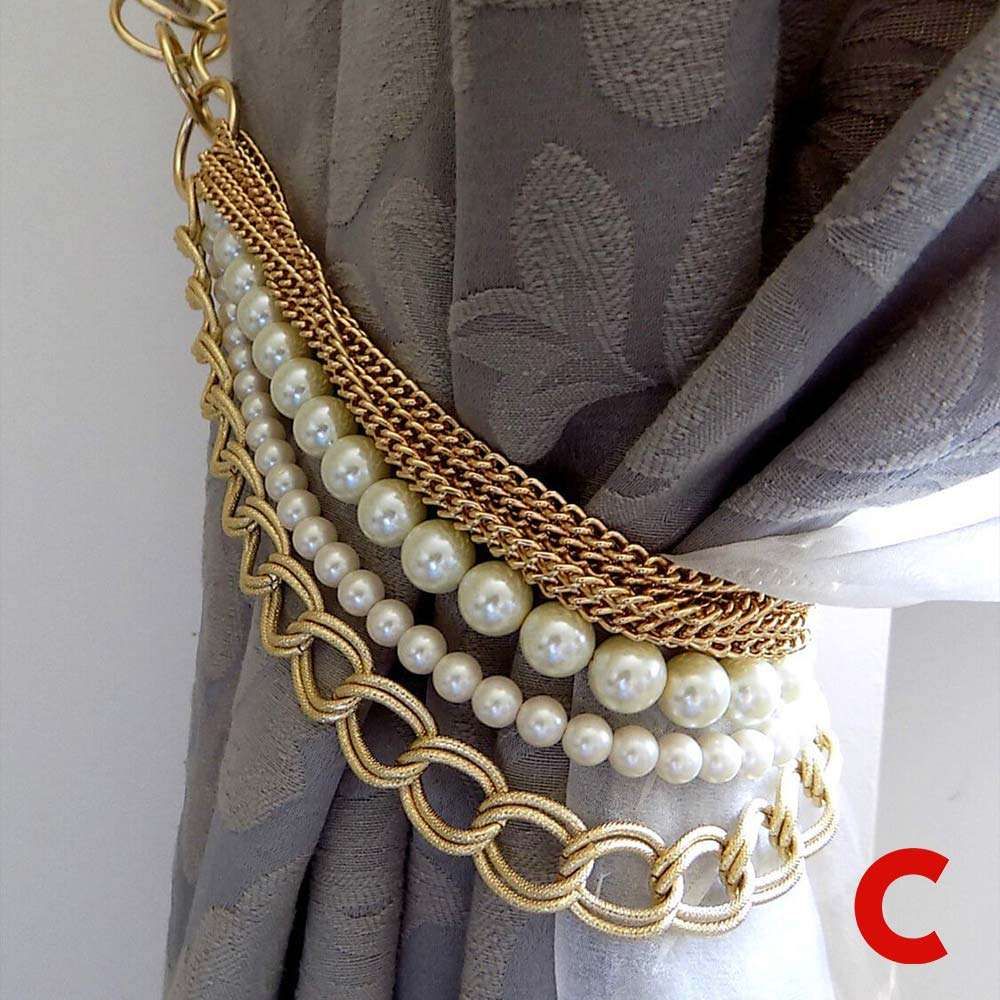 Gold chain and pearl-strand tieback gathering a grey damask curtain over a white sheer