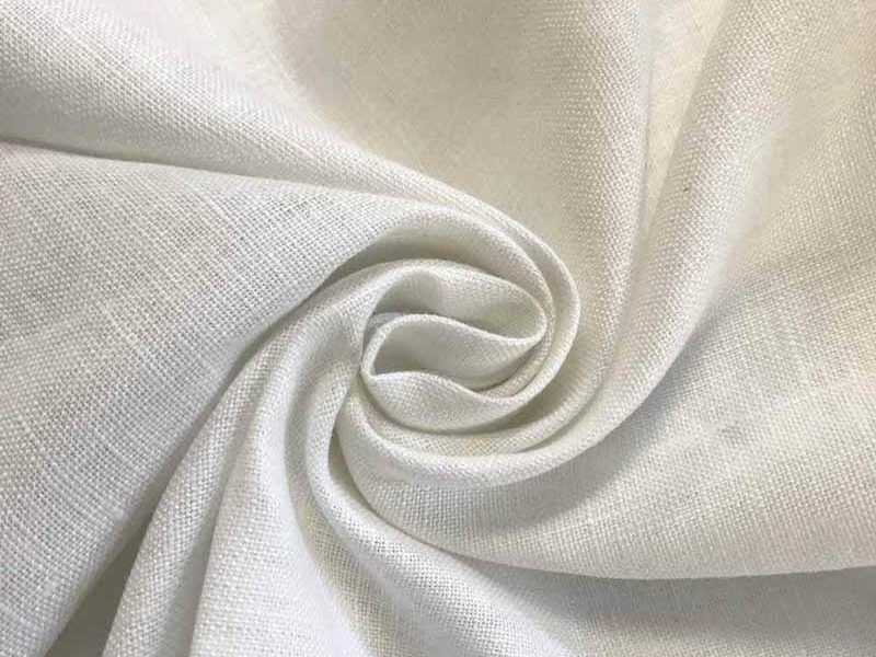 Close-up of white linen fabric swirled into a rosette, showing the plain open weave and soft creasing