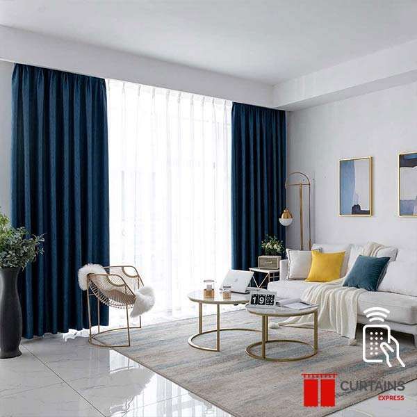 Navy curtains drawn back either side of a white sheer over a balcony door in a marble-floored living room