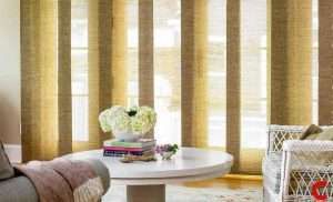 Mustard woven sliding panels wrapped around a curved bay window behind a round white table