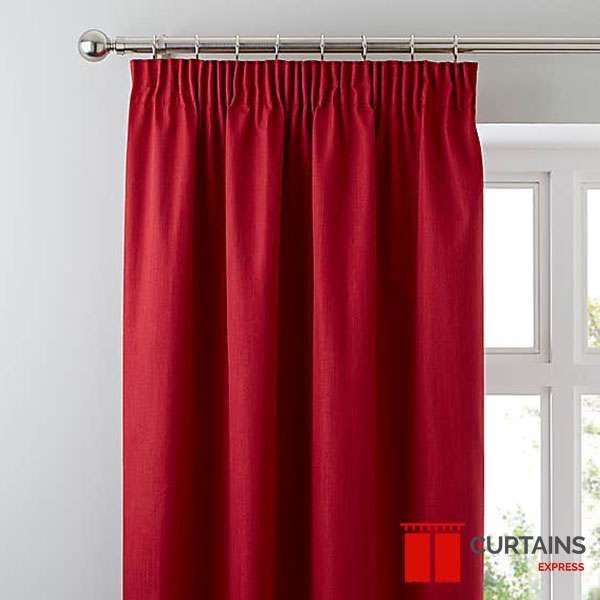 Close-up of a red pencil-pleat curtain heading on a chrome pole beside a white window frame
