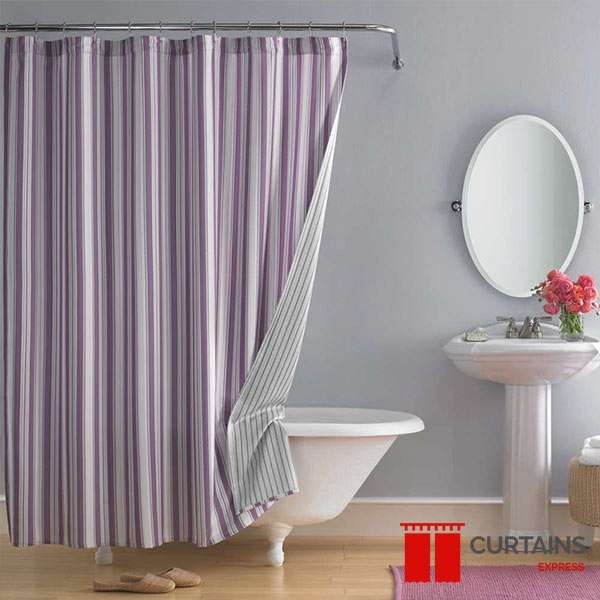 Purple and white striped shower curtain on a chrome rail, one corner folded back over a clawfoot bath