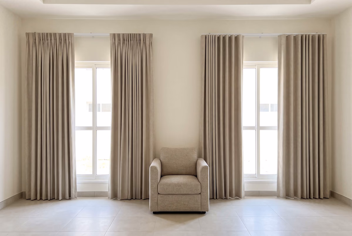 Two matching villa windows in the same beige fabric, the left pair in a pinch pleat heading and the right pair in a wave heading